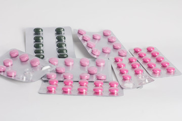 Blister pack of pink ,green pills isolated on white