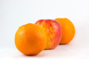 Oranges and apples in row on white background.