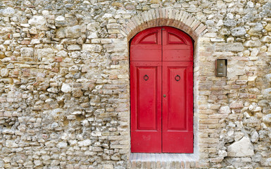 Rustic red door on the stone wall
