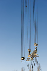 Naklejka premium Big harbor cranes hooks hanging on steel ropes.