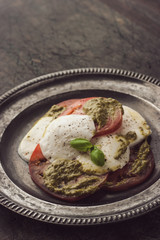 Caprese salad in the vintage metal plate vertical