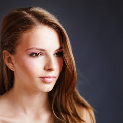 Fototapeta premium Young blonde girl applying make-up by make-up artist.