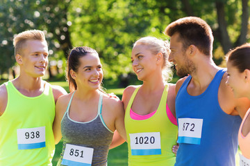 happy friends or couple with racing badge numbers