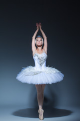 Portrait of the ballerina in ballet tatu on blue background