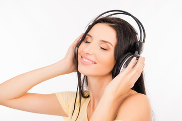 Naklejka premium Cute young woman enjoying music on headphones, smiling and close
