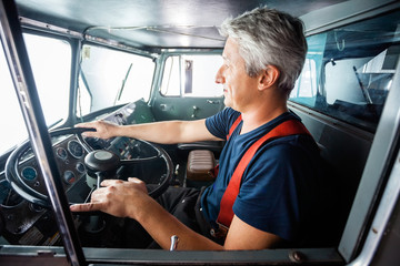 Fototapeta premium Mature Fireman Driving Firetruck