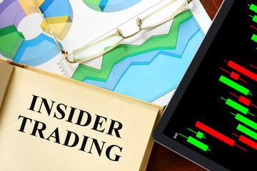 Words  written insider trading on a book. Business concept.