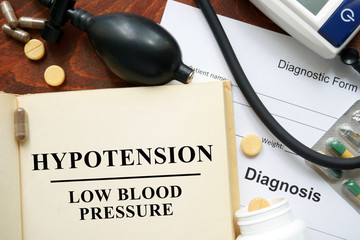 Low blood pressure Hypotension  written on a book and diagnosis form. 