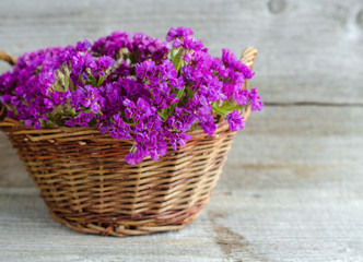 Basket with a bouquet of dried statice flowers