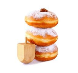 image of jewish holiday Hanukkah with donuts and wooden dreidel (spinning top). isolated on white

