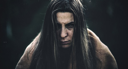 Dark halloween portrait of a girl with cracked skin and black eyes. Photo has added grain and other effects to look more realistic.