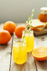 Orange juice in bottle on grey wooden background
