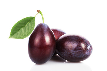 plums with leaves on white background.