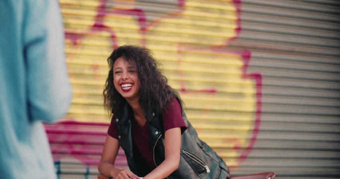 Teenage girl smiling at someone on a city street