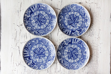 Set of vintage plates with blue floral ornament on wooden background