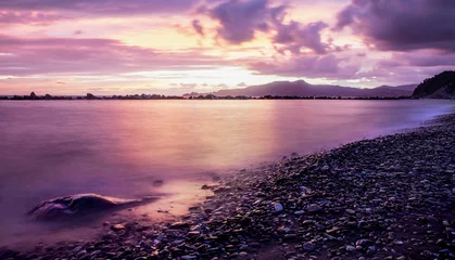 Zelfklevend Fotobehang Zonsondergang aan zee paarse zonsondergang op het strand