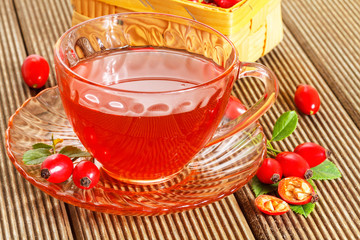 rose hip tea with fresh berries on the wooden background