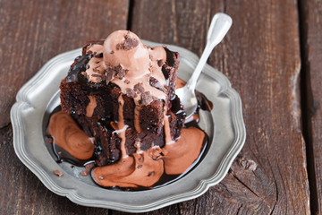 Chocolate brownie with raspberries in a chocolate glaze, served with a scoop of chocolate ice cream.selective focus