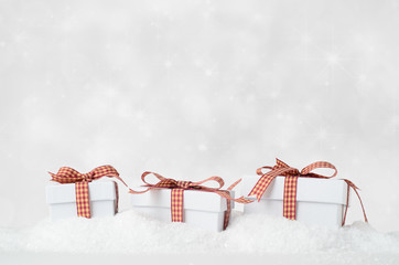 White Christmas Gift Boxes in Snow with Bokeh Background