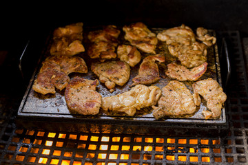 meat on the grill grate over a stone fireplace