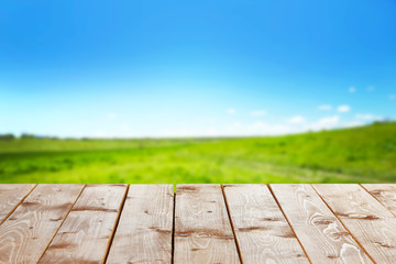 Fototapeta na wymiar Wooden table with field background
