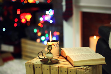 Composition with book, cup of hot drink on table, on colorful lights background
