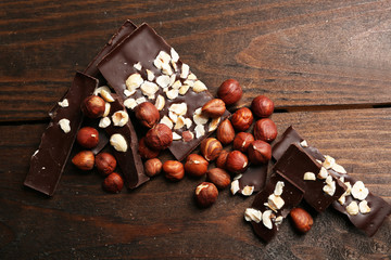 Chocolate pieces with nuts on wooden background