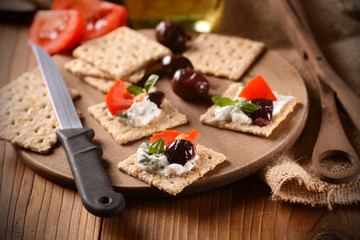 spuntino con formaggio alle erbe, olive e pomodoro