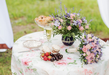 Served table outdoors. Flower arrangement with lavender and