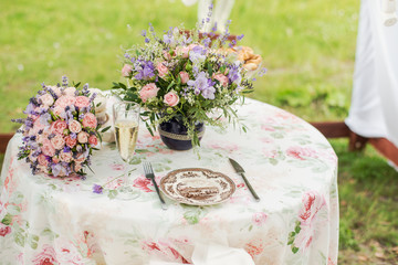 Served table outdoors. Flower arrangement with lavender and