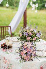 Served table outdoors. Flower arrangement with lavender and