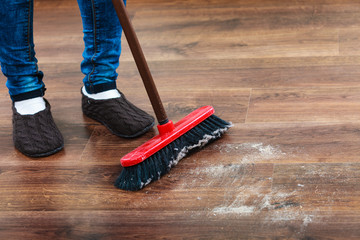 Cleaning woman sweeping wooden floor