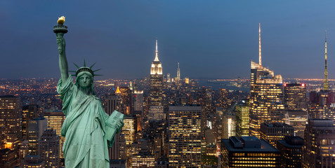 United States of America concept with statue of liberty in front of the New York cityscape at night - Powered by Adobe