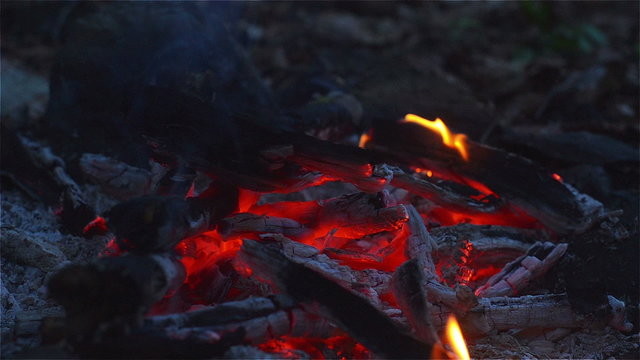 Fire and glow on a camping trip in the twilight at close range and blured background.
