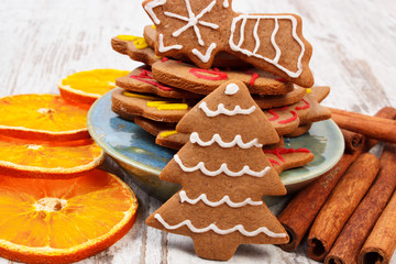 Decorated gingerbread with spices on old wooden background, christmas time
