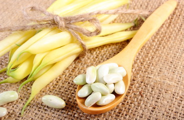 Seeds and stack of yellow beans on jute canvas, healthy food