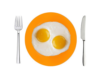 two fried eggs on orange plate, knife and fork isolated on white