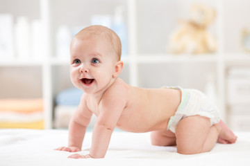 Adorable crawling baby on white blanket