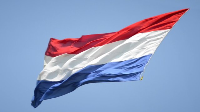 Dutch Flag of The Netherlands with red, white and blue stripes in the wind.