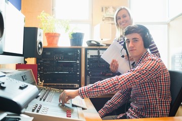 Portrait of male radio host using sound mixer