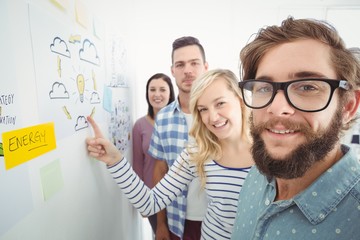 Obraz premium Smiling business team next to wall with sticky notes