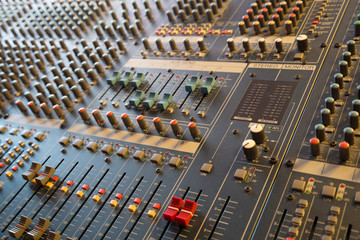Faders and knobs on professional musical mixer