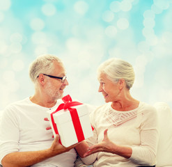 happy senior couple with gift box at home