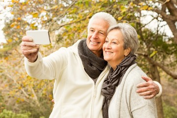 Senior couple in the park taking selfie