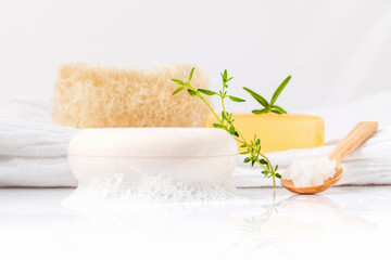 Herbal spa soap bar on white bath towel with thyme,rosemary and