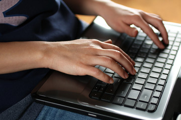 the laptop lies on the feet of the girl and she prints