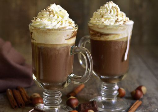 Hot chocolate with cinnamon and hazelnuts in a glass.