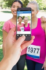 Composite image of female hand holding a smartphone