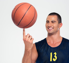 Portrait of a happy man spinning basketball ball