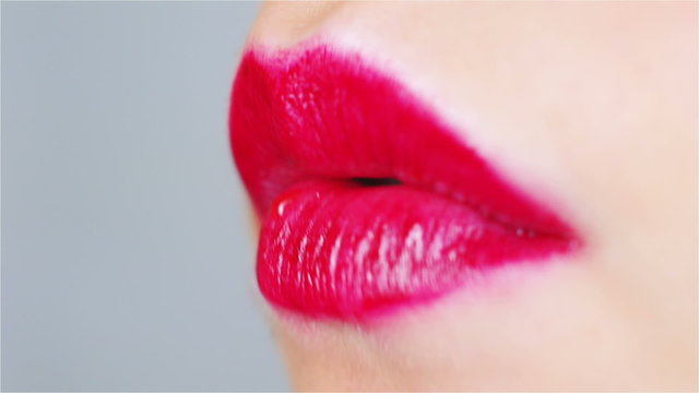 Sensual red lips bite strawberry. A close up with a lot of sweet and juicy experience.

